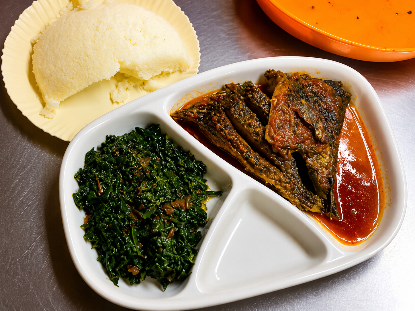 Fish stew served with ugali and greens